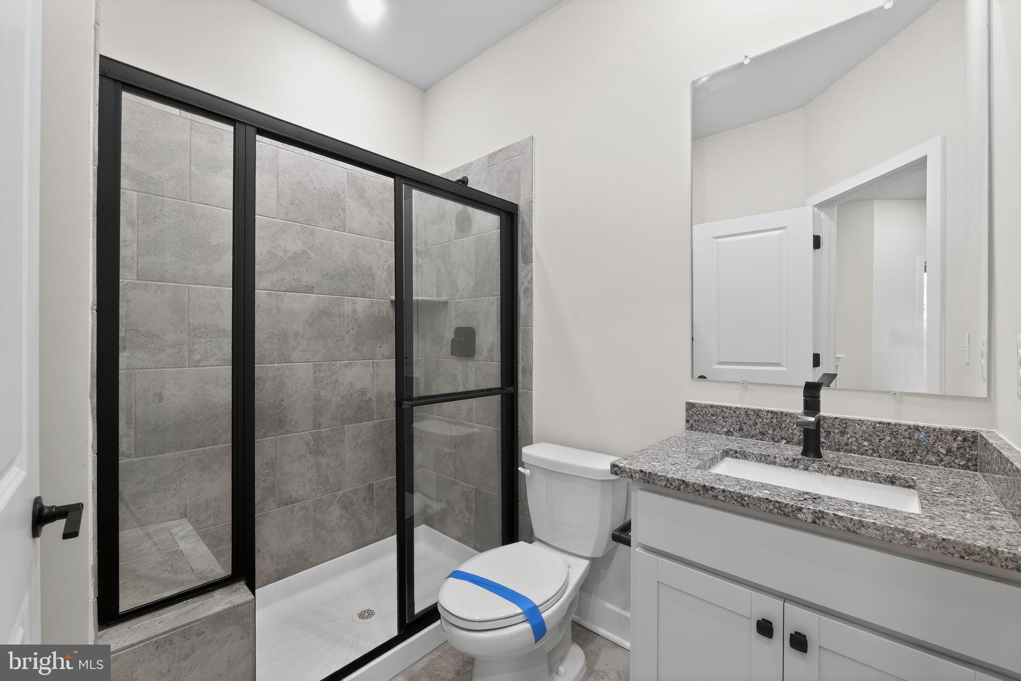 1505 Roland Heights Avenue Baltimore, MD 21211 - Photo 34 of 36 a bathroom with a granite countertop sink toilet and shower