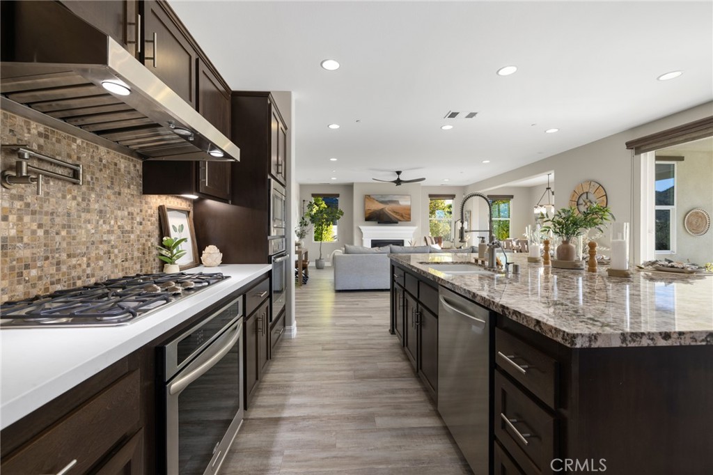 25313 High Noon Court Menifee, CA 92584 - Photo 27 of 73 a kitchen with stainless steel appliances granite countertop a stove a sink dishwasher and a refrigerator