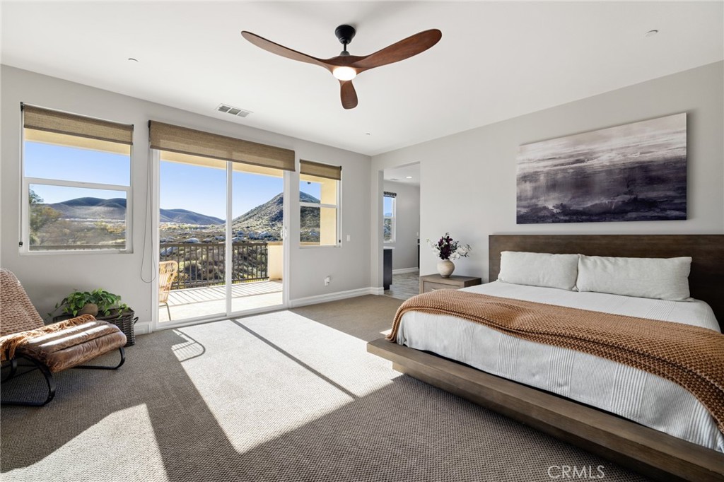 25313 High Noon Court Menifee, CA 92584 - Photo 43 of 73 a spacious bedroom with a bed a couch and a large window