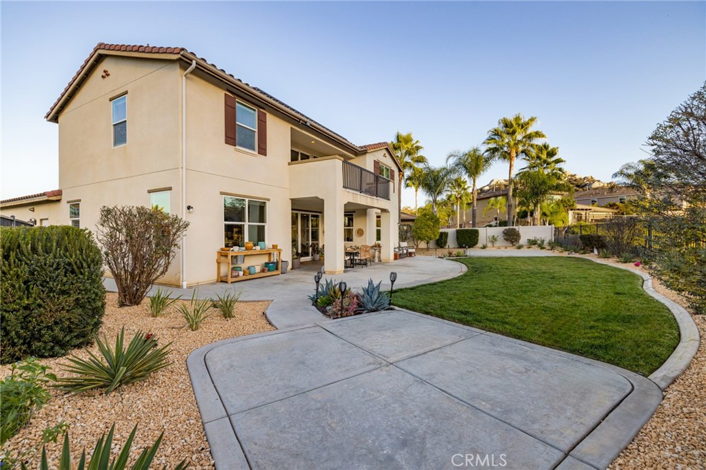 25313 High Noon Court Menifee, CA 92584 - Photo 50 of 73 a view of a white house with a big yard and potted plants