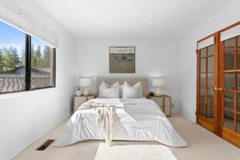 a bed sitting in a bedroom next to a window