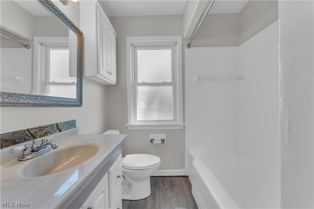 3842 Wallingford Road South Euclid, OH 44121 - Photo 19 of 31 Full bathroom featuring washtub / shower combination, toilet, hardwood / wood-style flooring, and large vanity