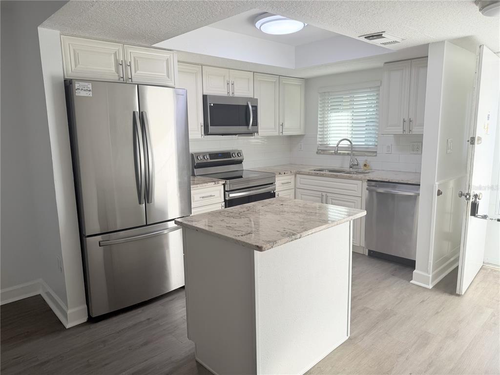1524 Lakeview Road, Unit 305 Clearwater, FL 33756 - Photo 3 of 18 a kitchen with stainless steel appliances a refrigerator sink and microwave
