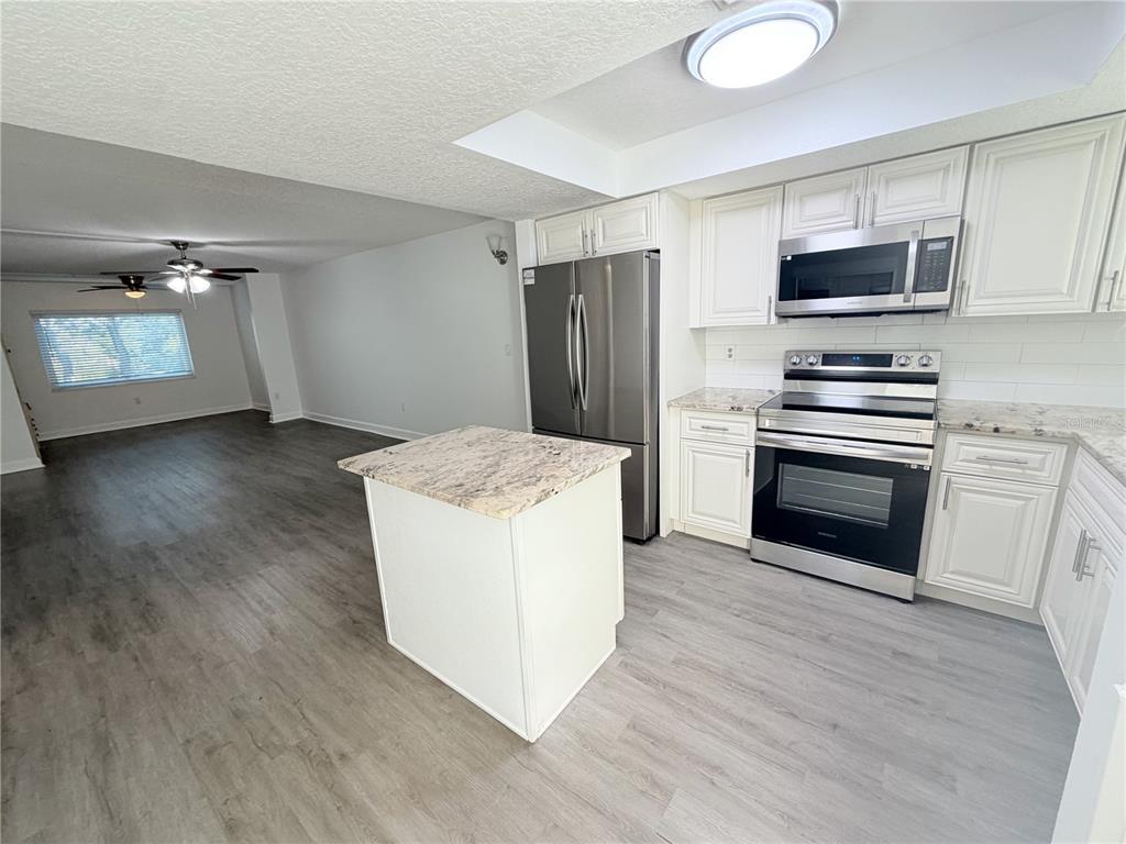 1524 Lakeview Road, Unit 305 Clearwater, FL 33756 - Photo 5 of 18 a kitchen with a sink wooden floor and stainless steel appliances