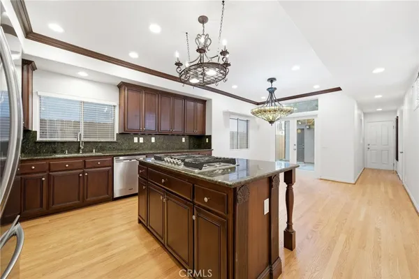a kitchen with a stove a sink a refrigerator and a view of living room