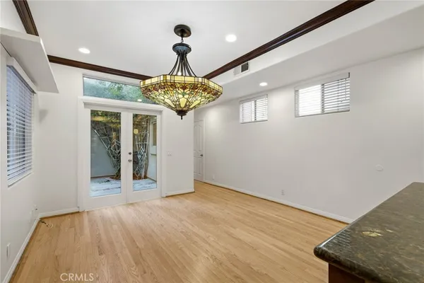 en empty room with wooden floor and chandelier
