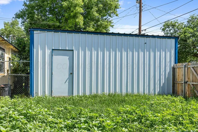 an outdoor view of backyard with potted plants and wooden fence