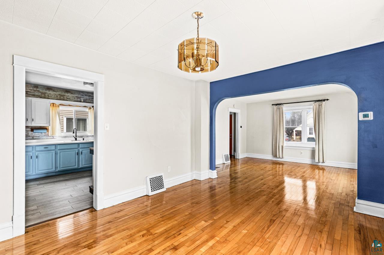607 3rd Avenue East Superior, WI 54880 - Photo 11 of 41 Unfurnished dining area with light wood-type flooring, arched walkways, and suspended lighting