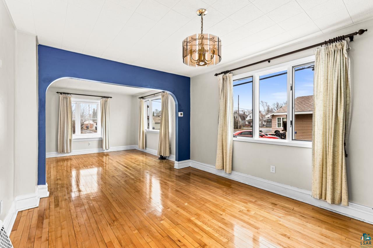 607 3rd Avenue East Superior, WI 54880 - Photo 12 of 41 Spare room with arched walkways, light wood-style flooring, and a chandelier