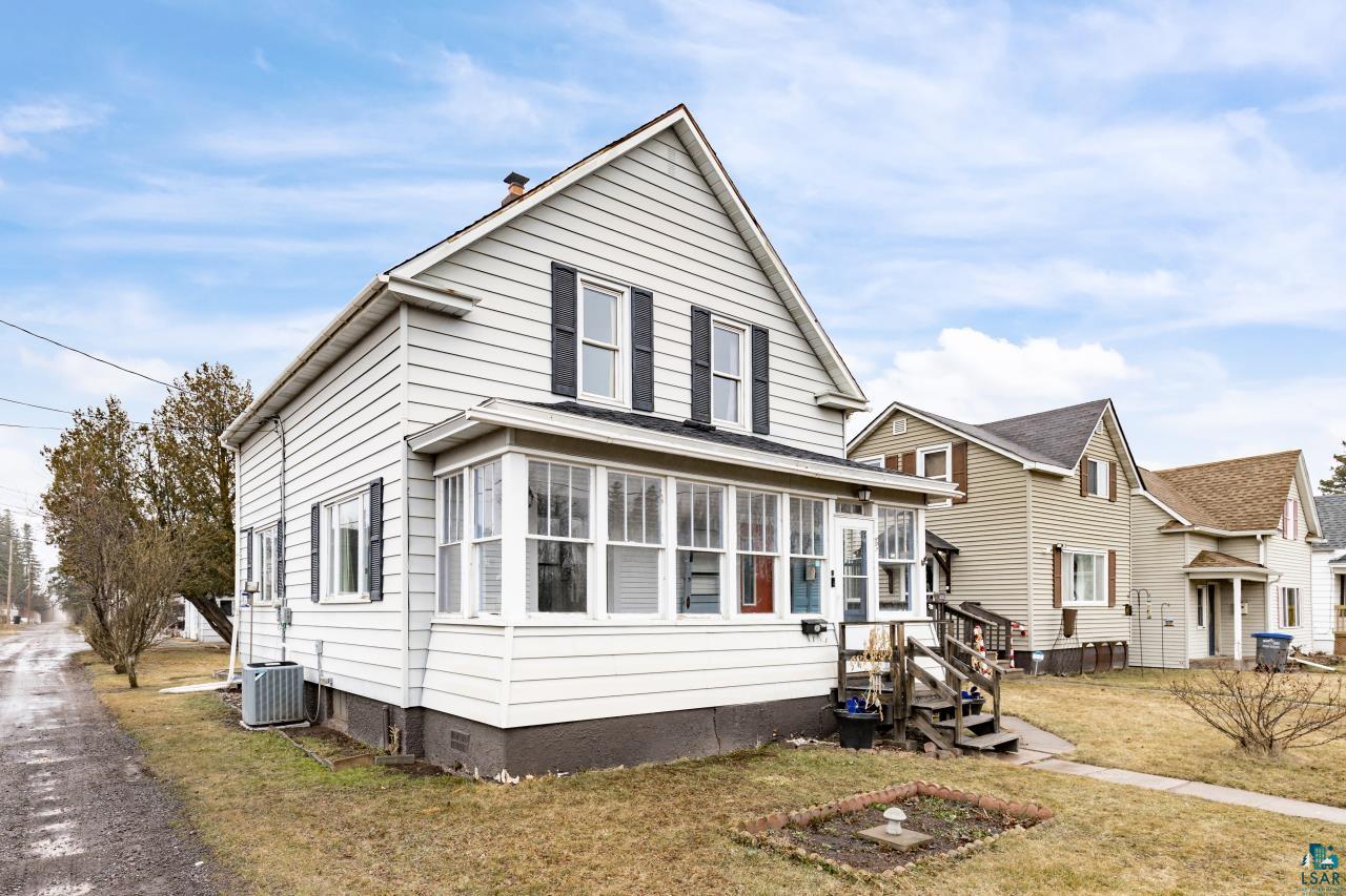 607 3rd Avenue East Superior, WI 54880 - Photo 2 of 41 View of front of property featuring a sunroom, a front yard, and a chimney