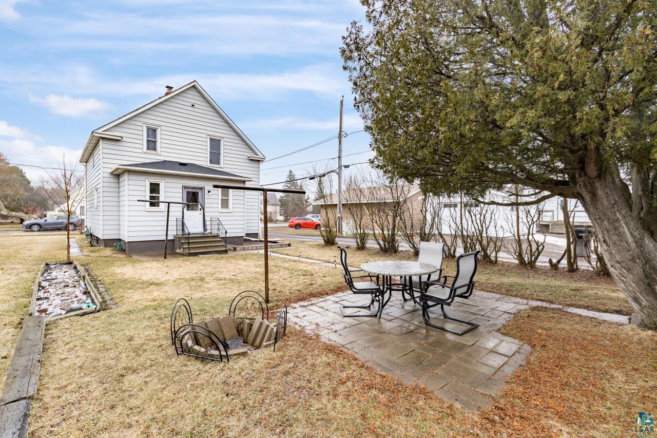 607 3rd Avenue East Superior, WI 54880 - Photo 33 of 41 Back of property with a patio area, a lawn, outdoor dining area, and roof with shingles