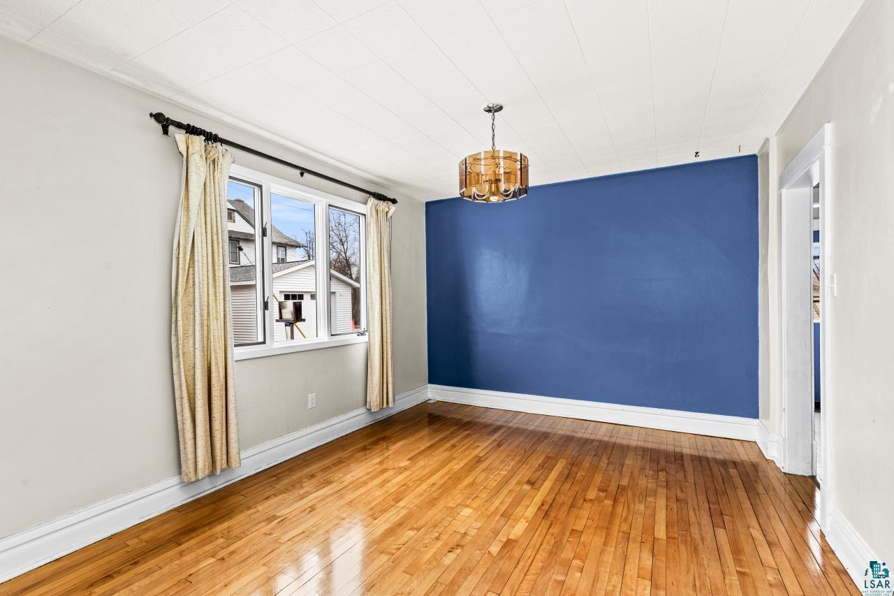 607 3rd Avenue East Superior, WI 54880 - Photo 9 of 41 Empty room featuring light wood finished floors and hanging lights