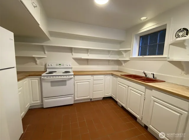 a kitchen with white cabinets and white appliances