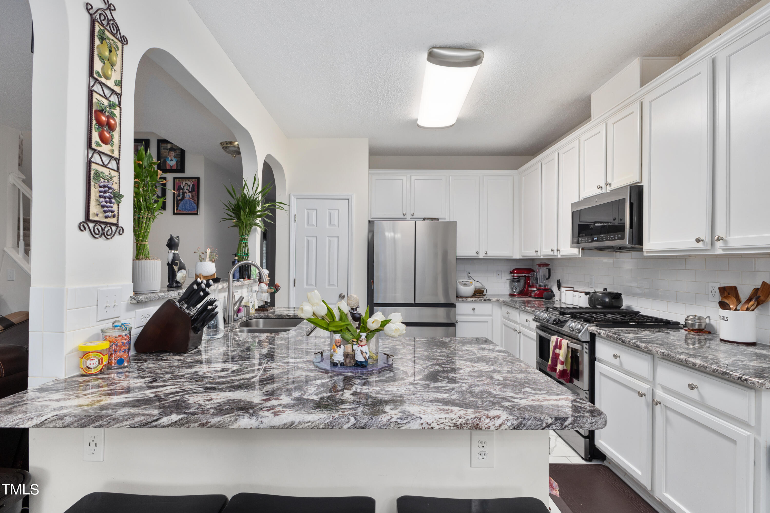 3 Weeping Beech Way Durham, NC 27713 - Photo 5 of 26 a kitchen with kitchen island granite countertop a sink a stove and refrigerator