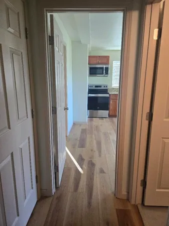 a kitchen with wooden floor and electronic appliances