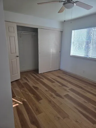 a view of empty room with window and ceiling fan