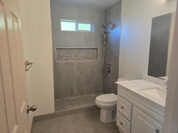 a bathroom with a sink a toilet and shower