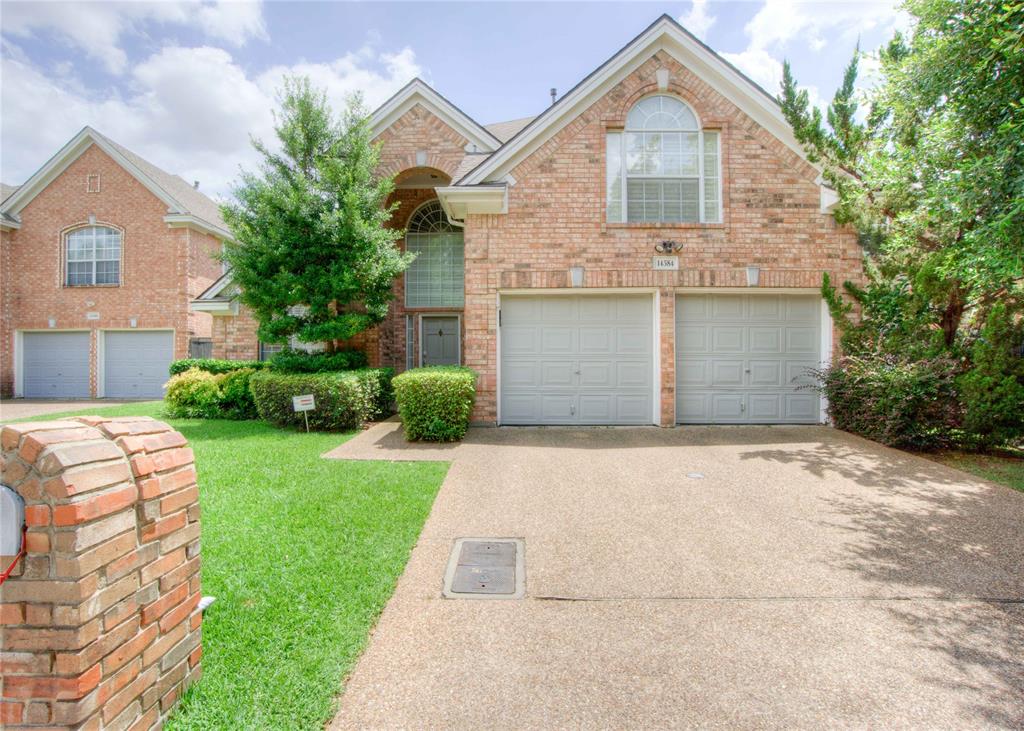 Traditional-style house featuring brick siding, concrete driveway, a front yard, and an attached garage