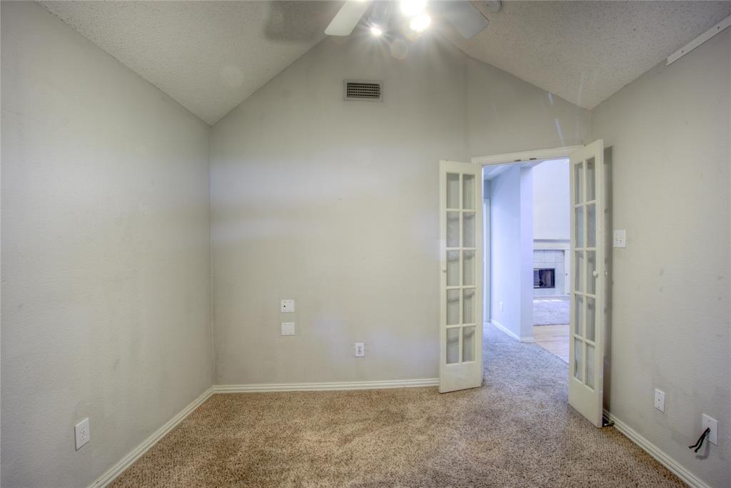 14584 Whitman Court Addison, TX 75001 - Photo 15 of 24 Empty room with lofted ceiling, carpet, french doors, a ceiling fan, and a textured ceiling