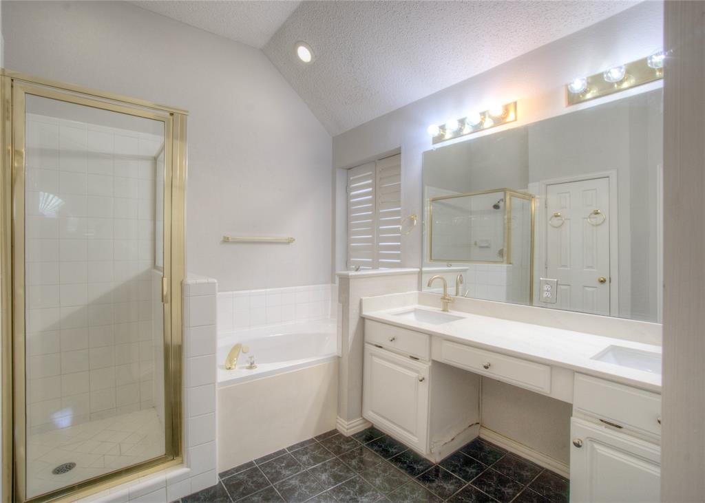 14584 Whitman Court Addison, TX 75001 - Photo 22 of 24 Full bathroom with a textured ceiling, a stall shower, vaulted ceiling, a bath, and double vanity