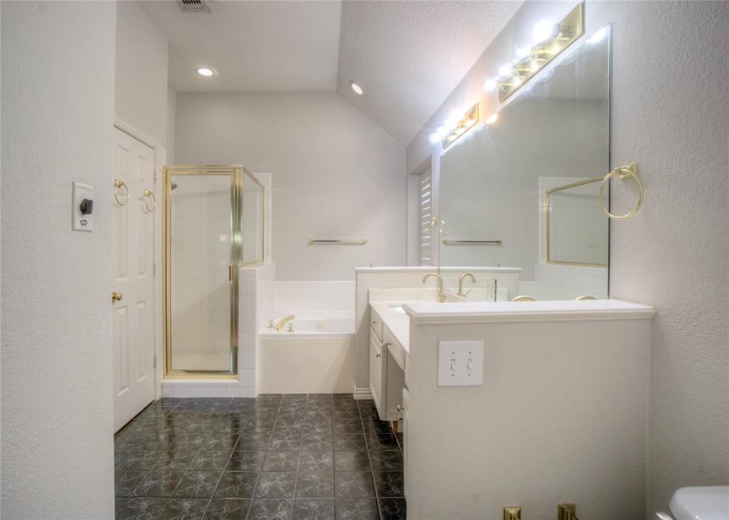 14584 Whitman Court Addison, TX 75001 - Photo 23 of 24 Full bath featuring a textured wall, a bath, a stall shower, a textured ceiling, and lofted ceiling