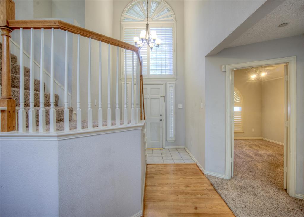 14584 Whitman Court Addison, TX 75001 - Photo 4 of 24 Foyer entrance with carpet, wood finished floors, plenty of natural light, and a chandelier