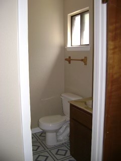 151-201 Springlake Drive Dripping Springs, TX 78620 - Photo 9 of 12 a bathroom with a granite countertop toilet a sink and a mirror