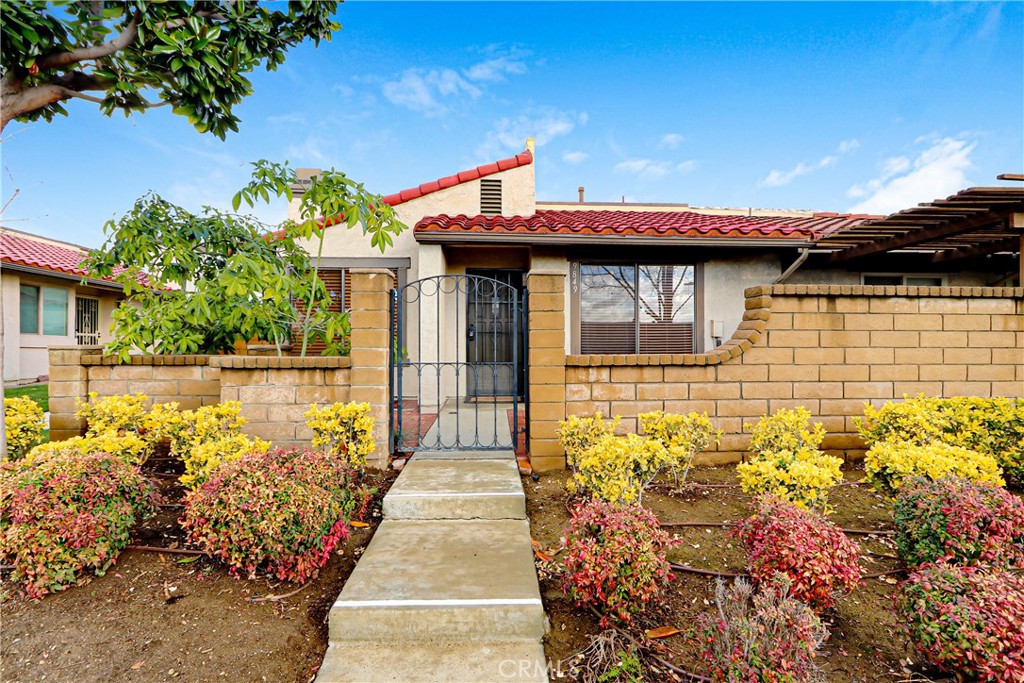 a front view of a house with a large window and potted plants