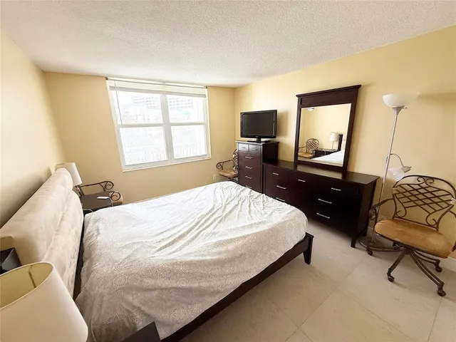 a bedroom with a bed and a television