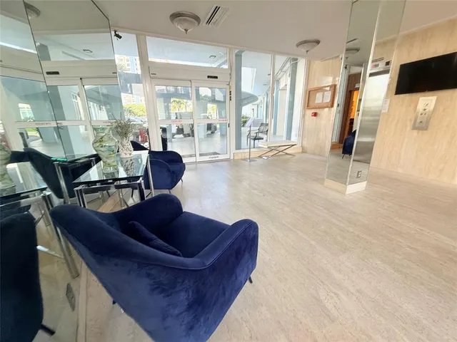 a living room with couches and kitchen view with wooden floor
