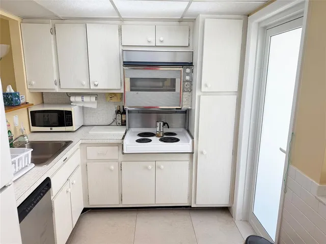 a kitchen with white cabinets and white appliances