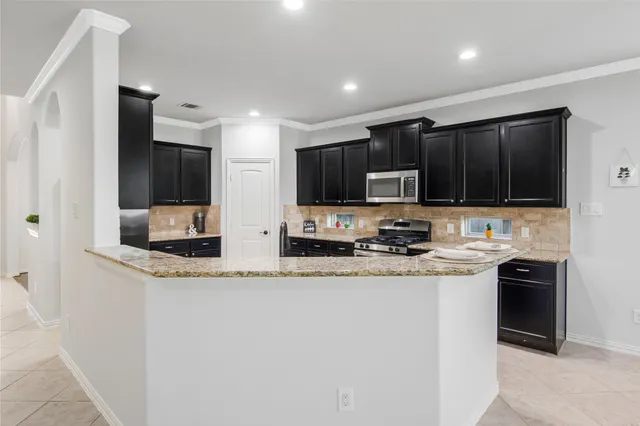 a kitchen with stainless steel appliances granite countertop a sink stove and cabinets