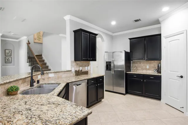a kitchen with granite countertop a sink stainless steel appliances and cabinets