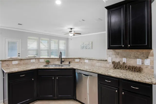a view of an empty room with a kitchen and a window