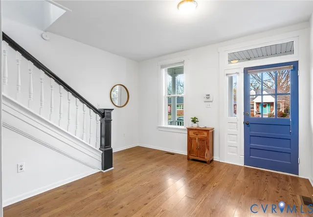 a view of entryway and hall with wooden floor