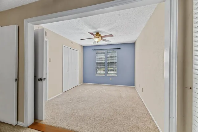 a view of a bedroom with cabinet ceiling fan and window