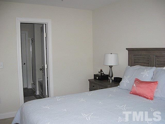 7641 Weathered Oak Way Raleigh, NC 27616 - Photo 11 of 20 a bedroom with a bed and a lamp