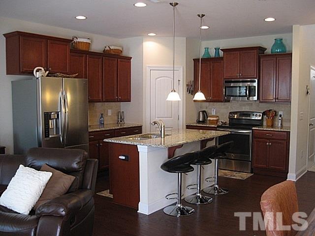 7641 Weathered Oak Way Raleigh, NC 27616 - Photo 6 of 20 a kitchen with stainless steel appliances granite countertop a refrigerator a stove a sink a dining table and chairs