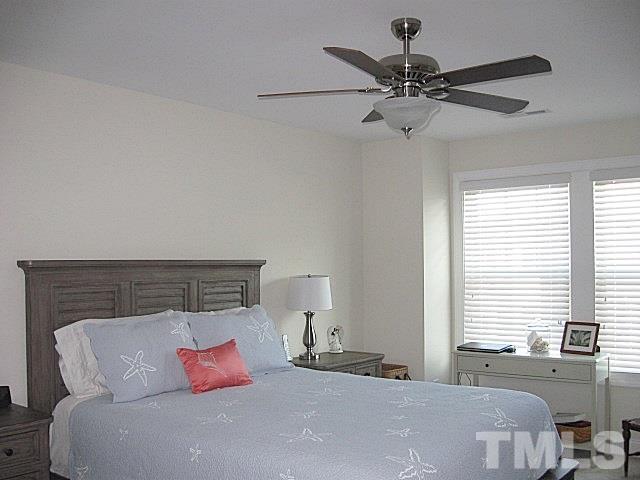 7641 Weathered Oak Way Raleigh, NC 27616 - Photo 8 of 20 a bedroom with a large bed and a chandelier fan