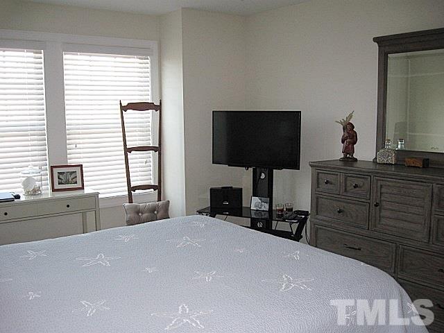 7641 Weathered Oak Way Raleigh, NC 27616 - Photo 9 of 20 a bedroom with a bed and a flat tv screen on dresser