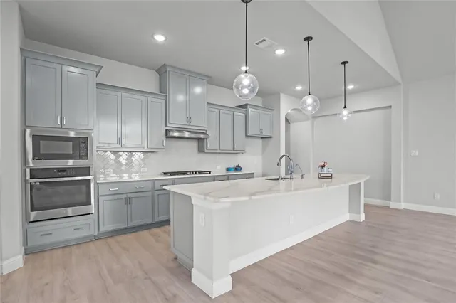 a view of a kitchen with a sink and dishwasher a refrigerator with wooden floor