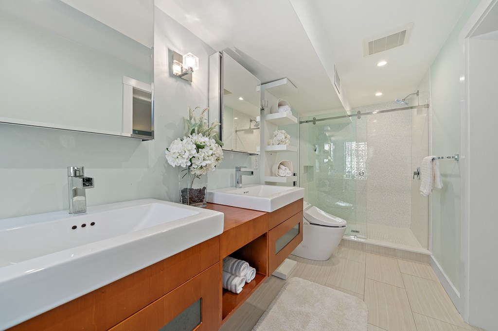 23 Claflin Road, Unit 1 Brookline, MA 02445 - Photo 21 of 41 a bathroom with a double vanity sink a toilet and shower