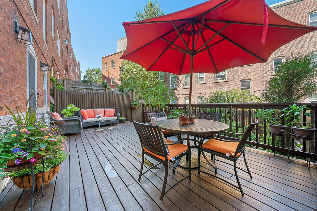 23 Claflin Road, Unit 1 Brookline, MA 02445 - Photo 33 of 41 a patio with wooden floor a yard a table and chairs