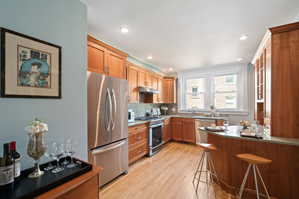 23 Claflin Road, Unit 1 Brookline, MA 02445 - Photo 9 of 41 a kitchen with a refrigerator a stove a sink dishwasher and wooden cabinets