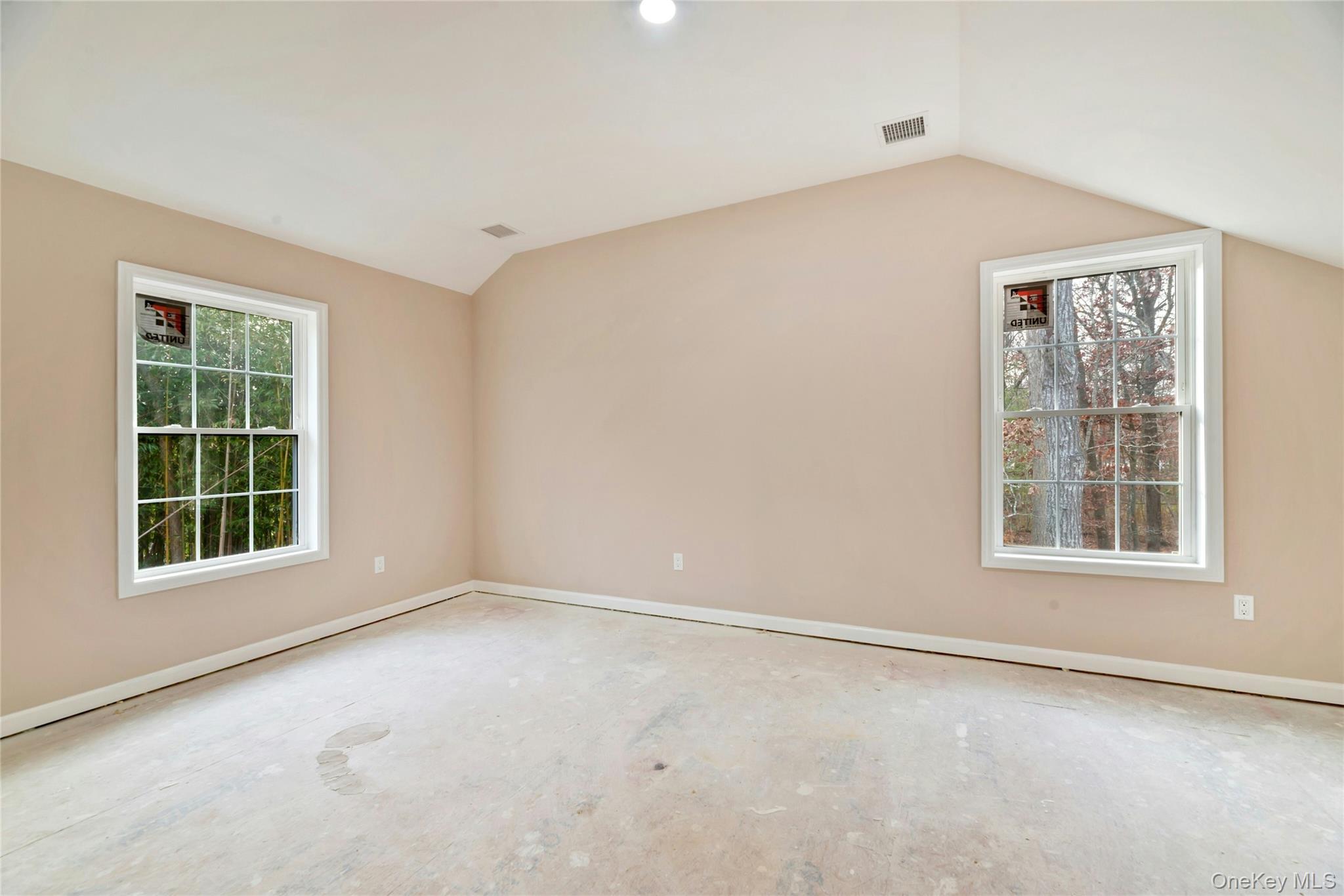 487 Neighborhood Road Shirley, NY 11967 - Photo 11 of 18 Spare room featuring baseboards and lofted ceiling