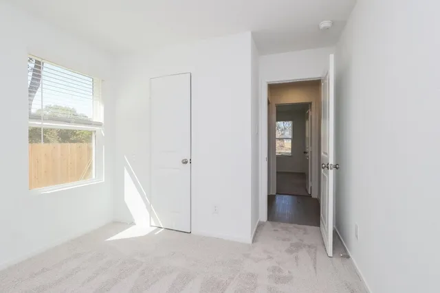 an empty room with windows and closet