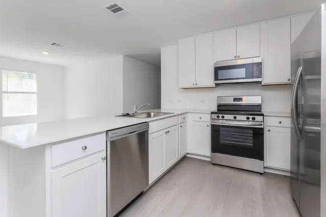 a kitchen with stainless steel appliances white cabinets and a stove