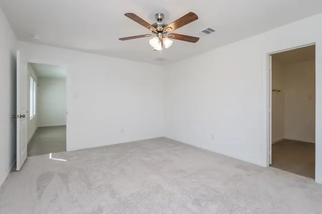 an empty room with fan and a ceiling fan