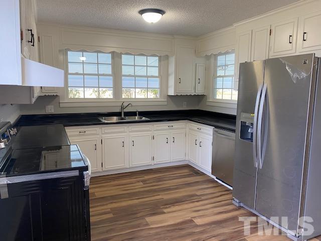 164 Jernigan Road Dunn, NC 28334 - Photo 9 of 30 a kitchen with granite countertop a refrigerator sink and cabinets
