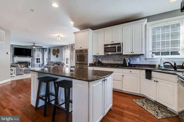 a kitchen island with granite countertop a sink counter top space and living room